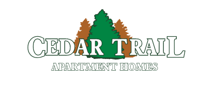 white lettering cedar trail apartment homes with green and brown trees behind the lettering